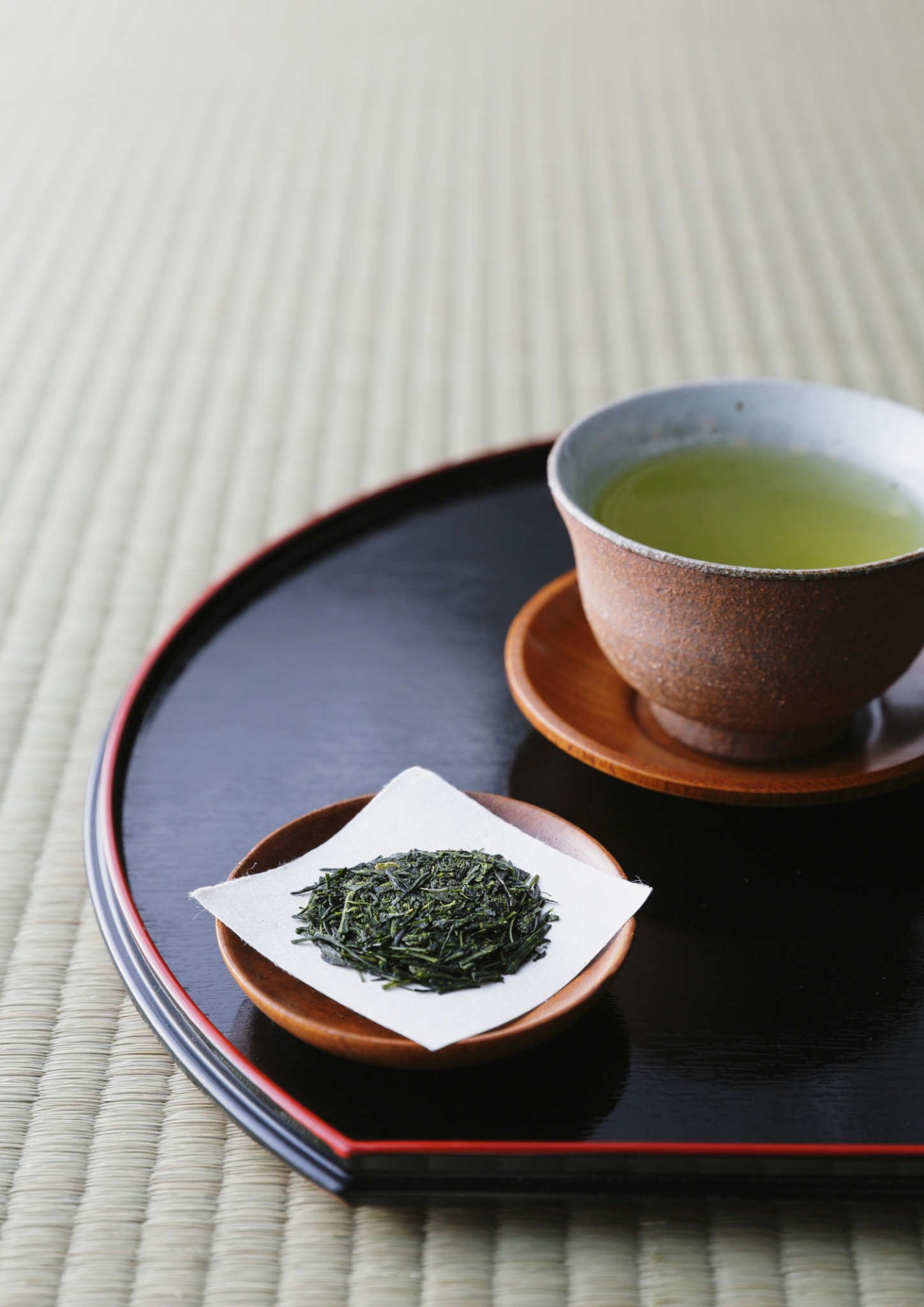お盆に並ぶ日本茶のカップと茶葉